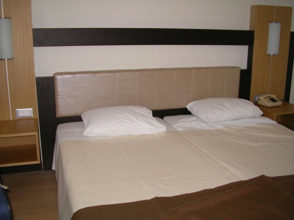 Das Bett in einem Doppelzimmer Pegasos Deluxe Beach Hotel