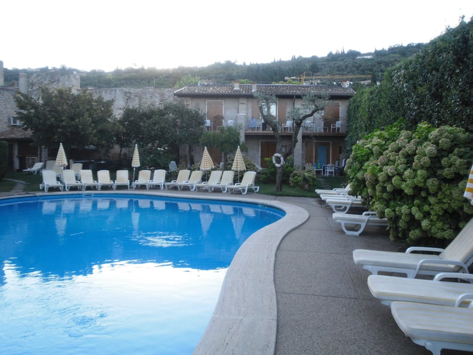 Der Pool am frühen Morgen mit Nebengebäude Hotel Romeo