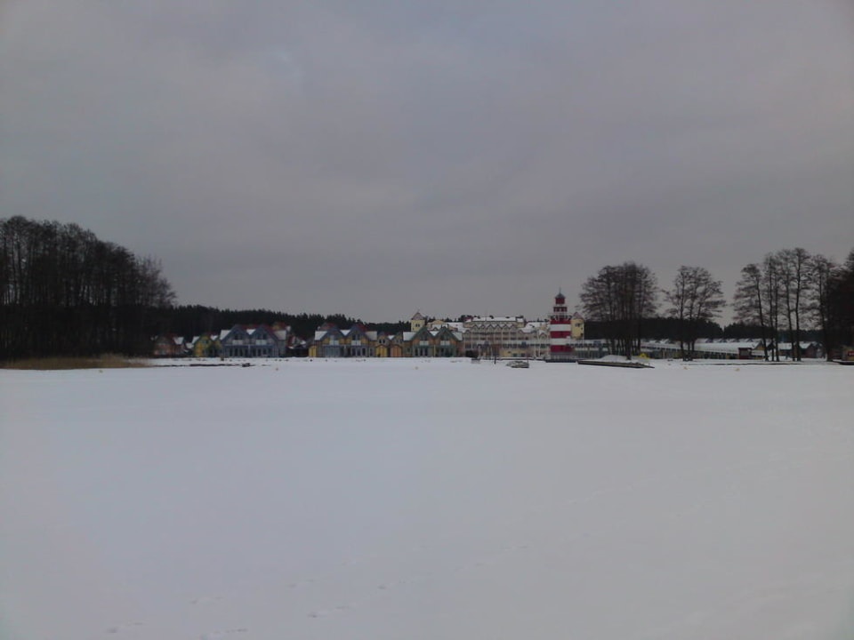 Hotelansicht vom zugefrorenen See Precise Resort Hafendorf Rheinsberg