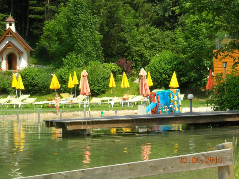 Blick über See, Liegewiese und Kapelle POST - Family Resort