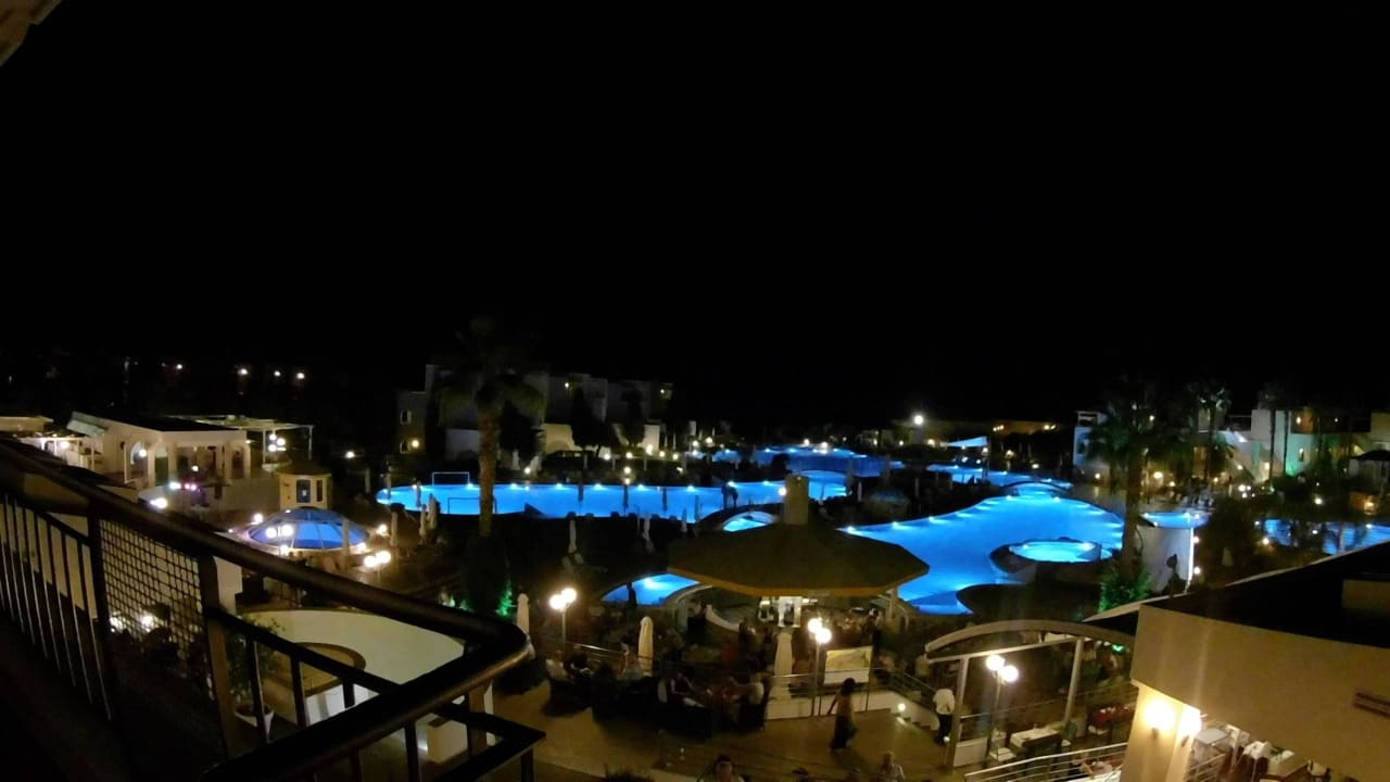 Blick auf Poolanlage mit Bar vom Balkon am Abend Atlantica Marmari Palace