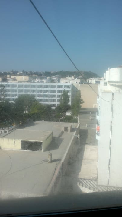 Widok z pokoju przez brudne okno na hotel Grand Mitsis La Vita