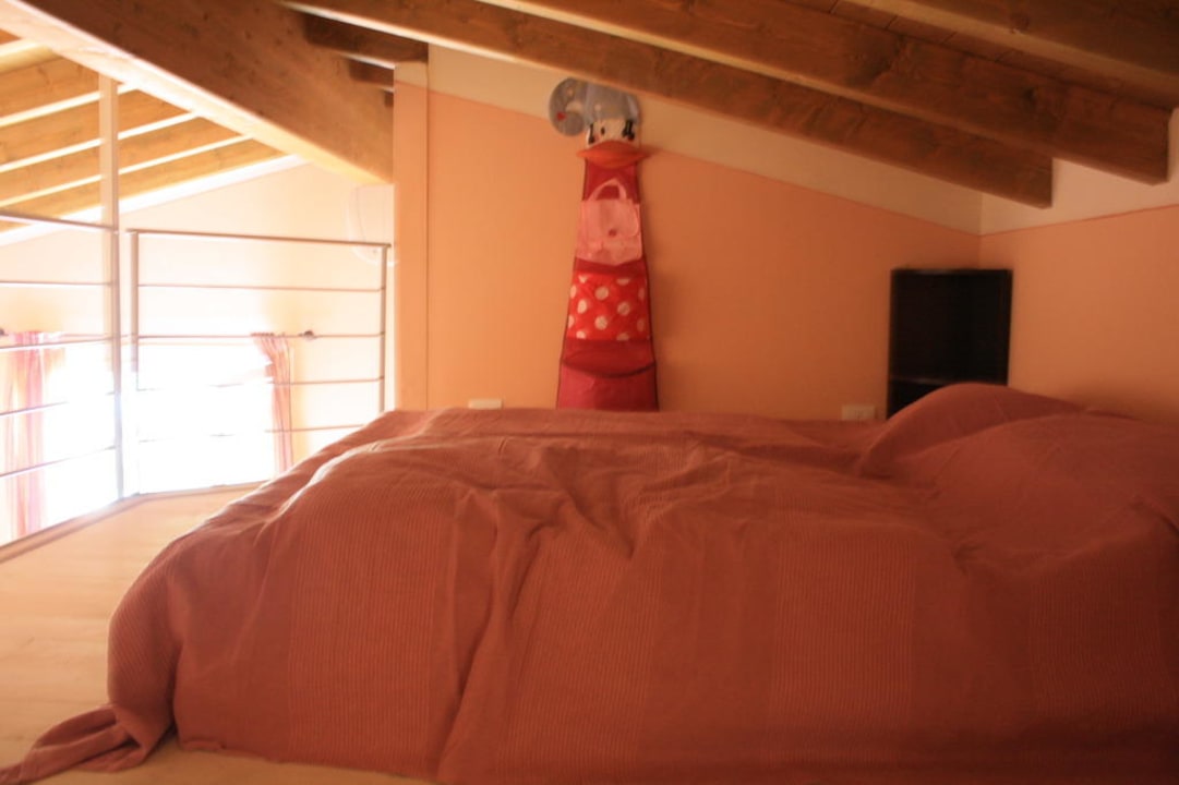 Bett auf der offenen Galerie Residence il Ruscello