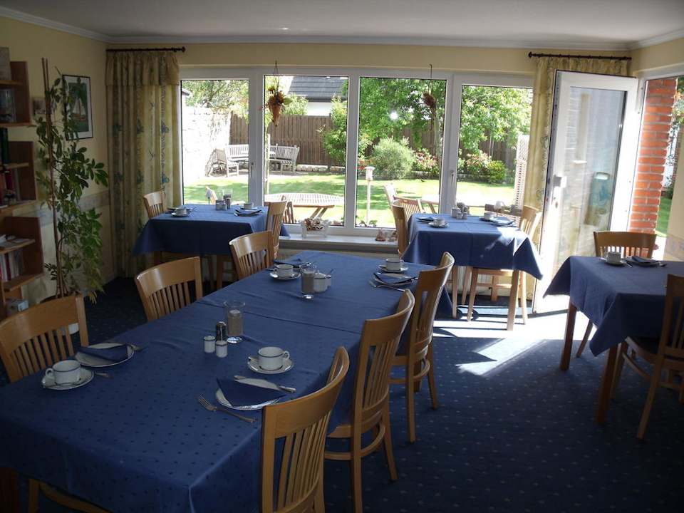 Frühstücksraum mit Blick in den Garten Gästehaus Buten & Binnen