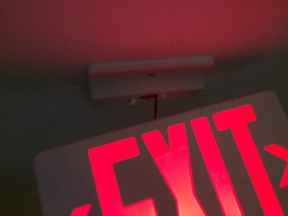 Nur an Kabel hängendes Notausgangschild Marien Puerto Plata