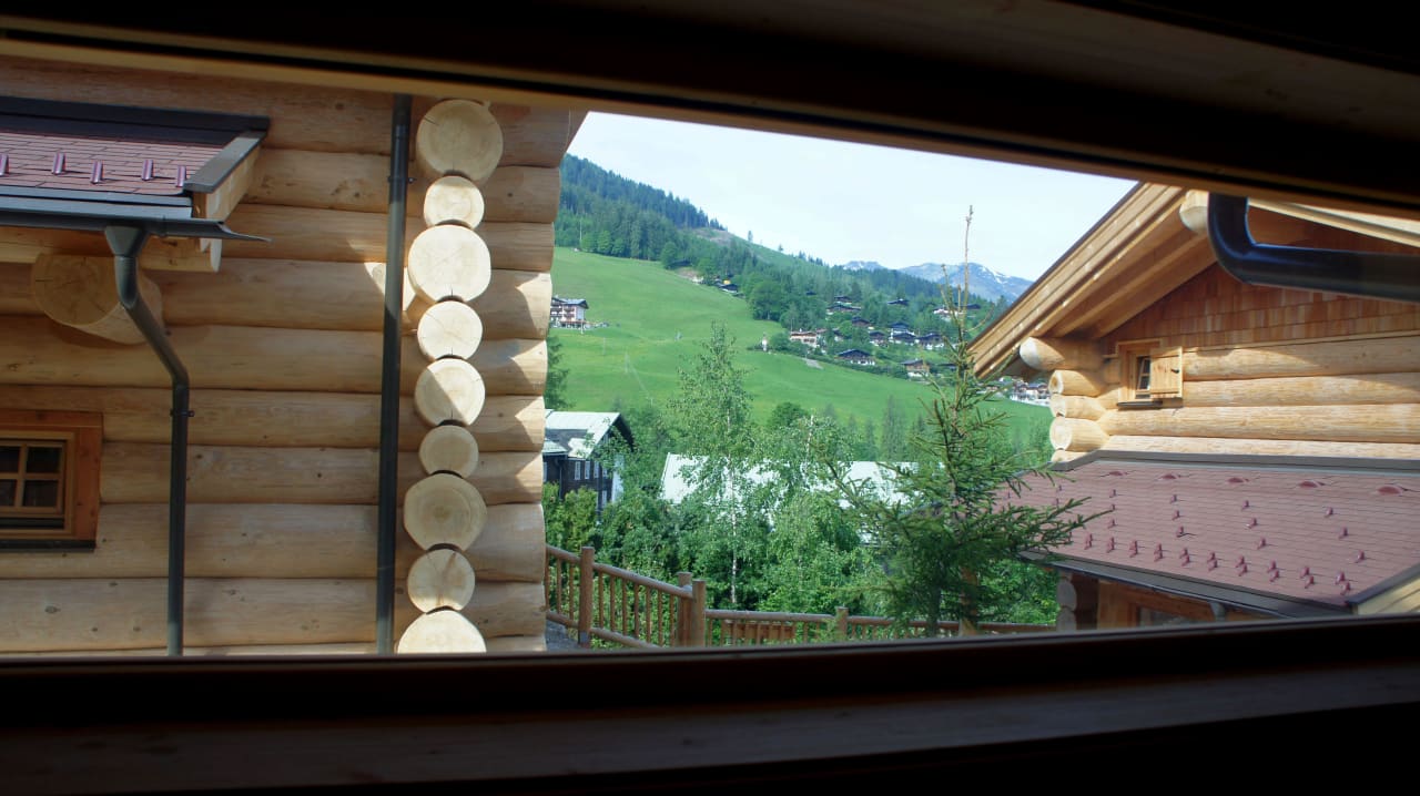 Mit verspiegelten Scheiben und Blick auf die Alm Hüttendorf Maria Alm