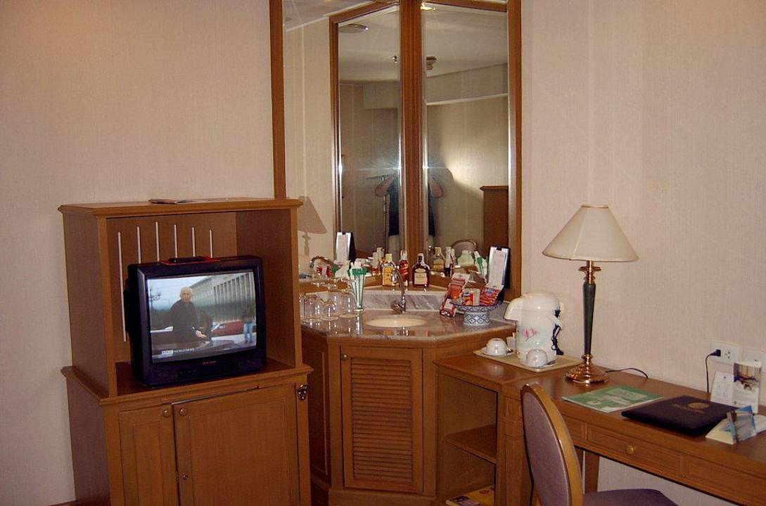 Wohnzimmer mit Fernseher und Spüle Hotel Windsor Suites & Convention