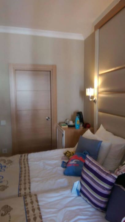 Bett und Türe zum Bad Quattro Beach Spa & Resort