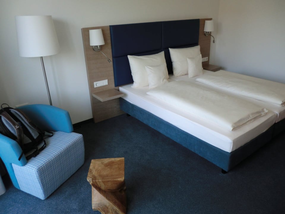 Bett, Sessel und echter hölzerner Tisch. Seehotel Kressbronn