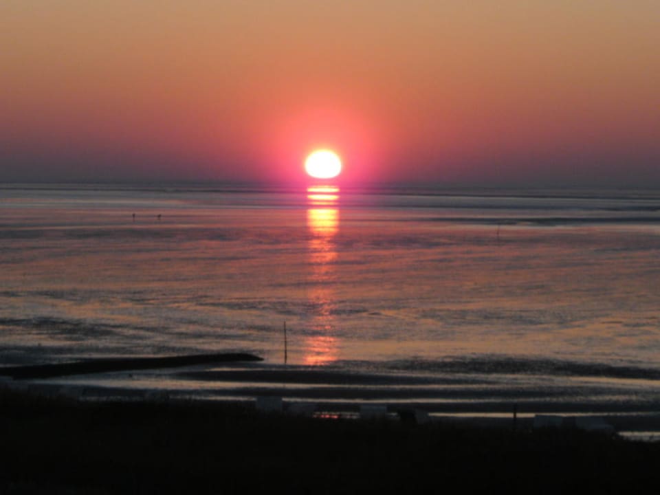 "Die Sonne zischt beim Untergang ins Meer" Beachhotel Cuxhaven