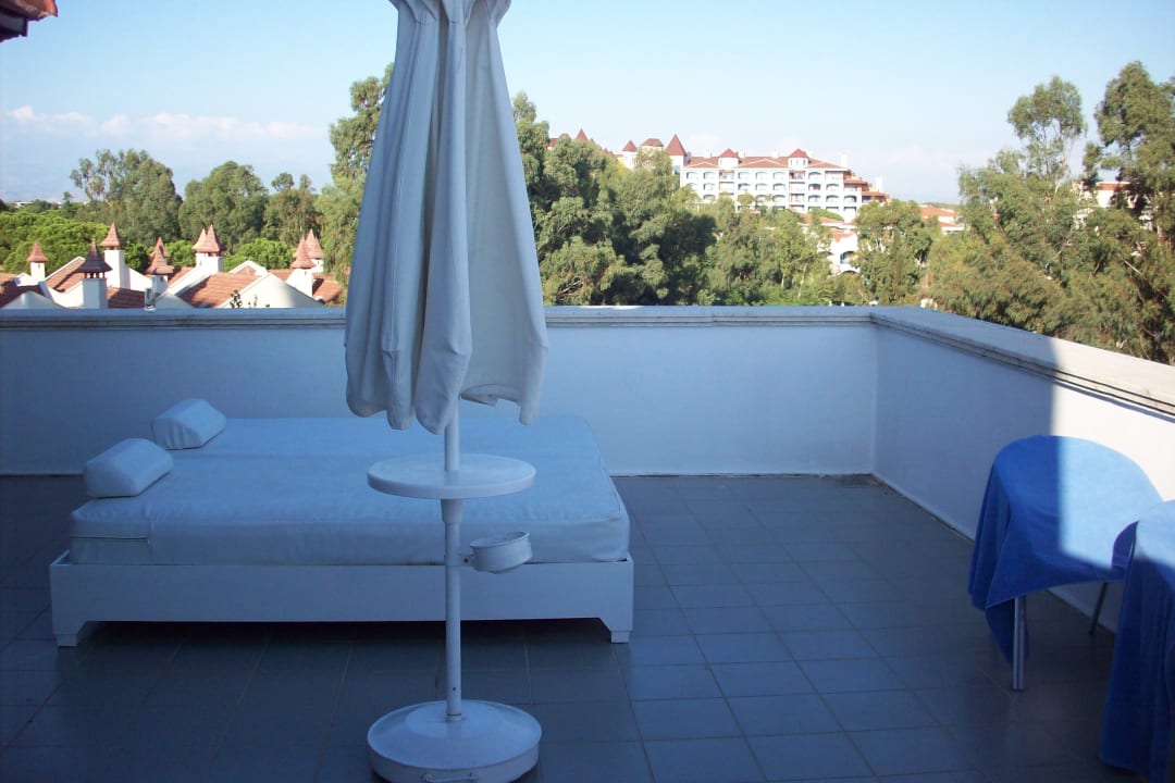 Große Terrasse mit Liegen und Schirm Green Max Hotel