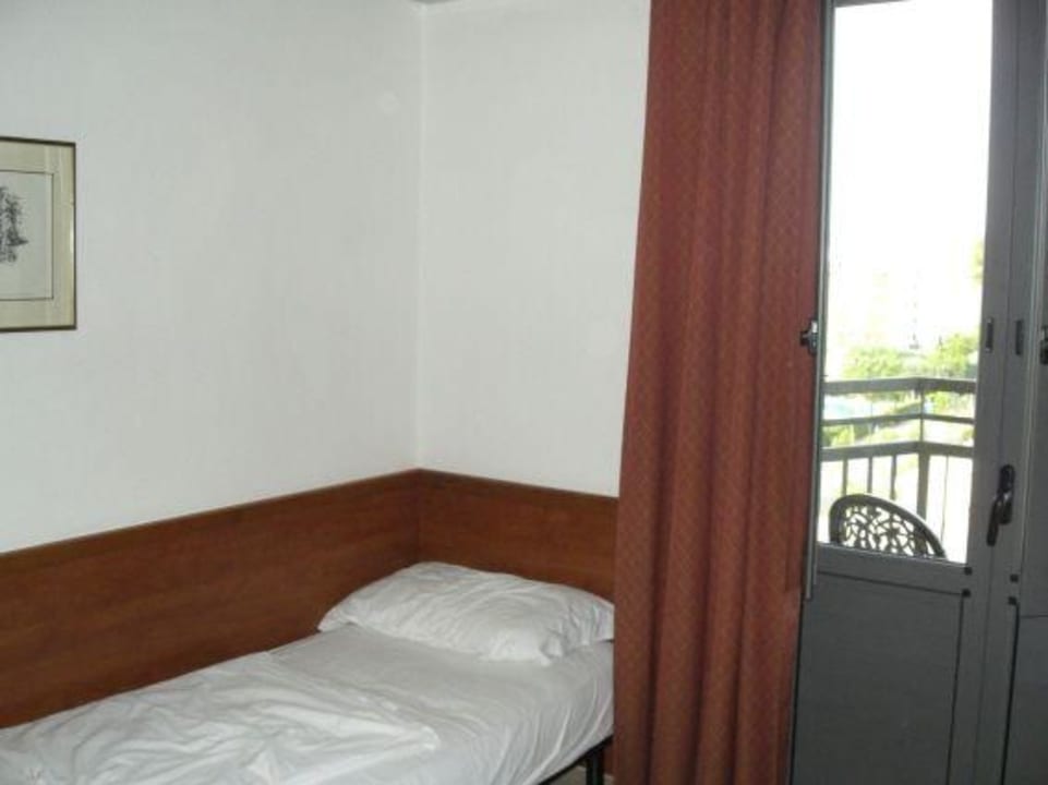 Кровать возле балкона Hotel Frank