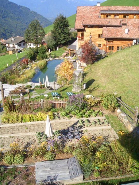 Blick vom Badehaus auf das Hotel und den Kräutergarten Naturhotel Lüsnerhof