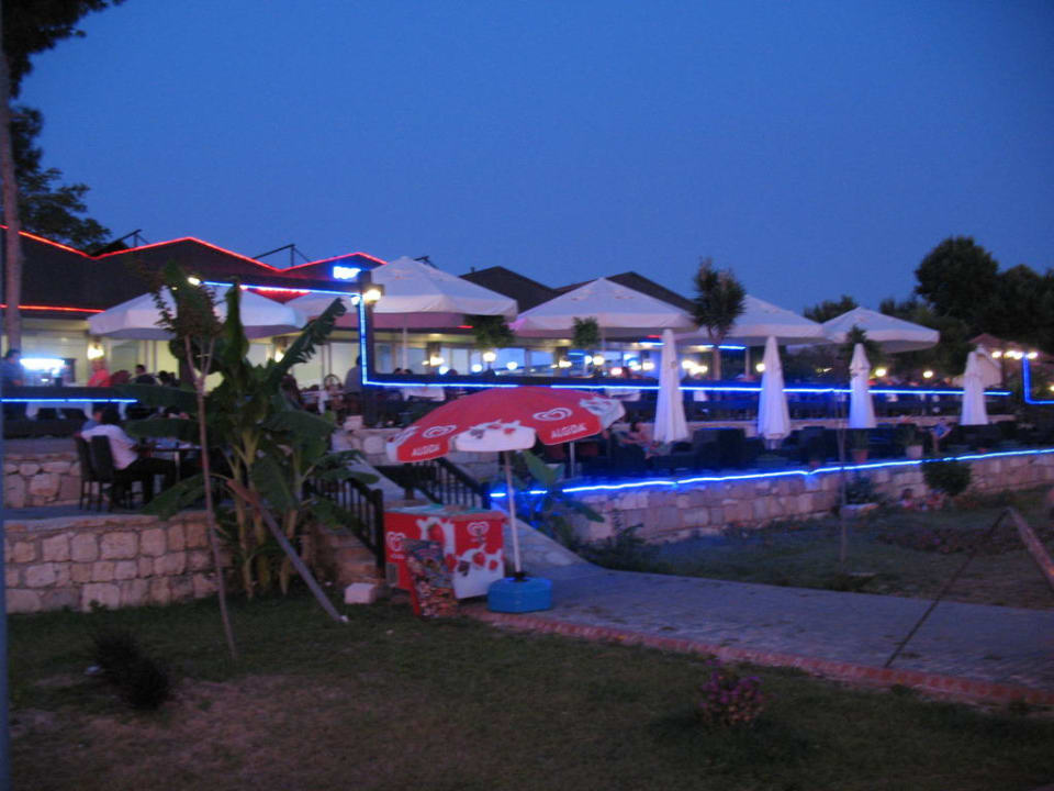 Blick vom Strand auf das Restaurant am Abend Clover Magic Nova Beach