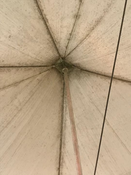 Gammeliger Schirm auf der Restaurantterrasse Summit Rainforest & Golf Resort