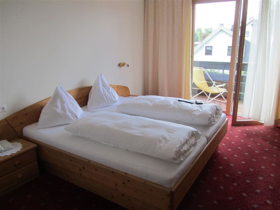 Bett und Blick auf den Balkon Gasthof Feichter