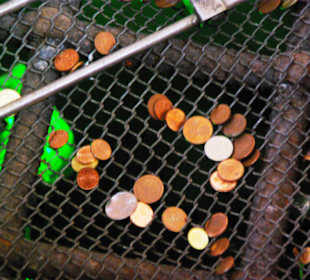 Viele Geldstücke am Brunnen