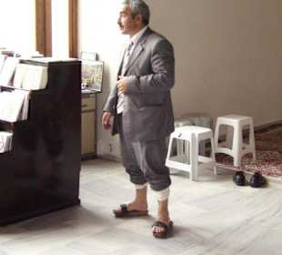 Moscheeaufseher mit Holzsandalen