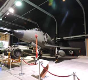 Militär und Zivilflugzeuge in einer Halle