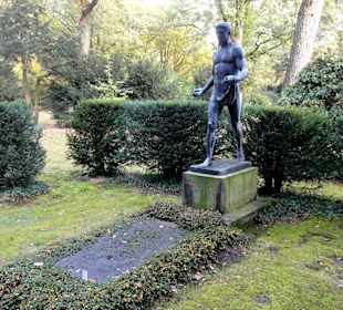 Skulptur vor einem alten Grab