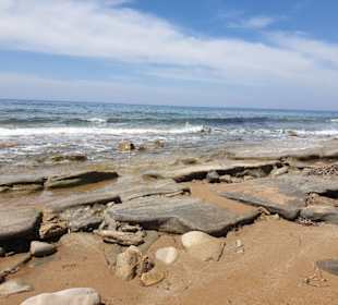 Strand mit Felsen und Sand