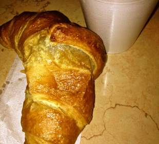 Croissant und schwarzer Kaffee