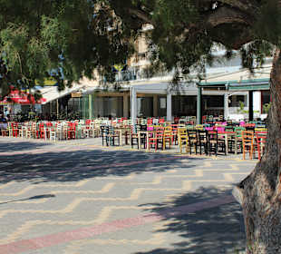 Kolorowe krzesła w tawernach przy porcie