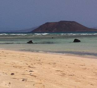 Schöner Strand, im Wasser viele Steine