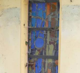 Buntglasfenster hinter Spinnweben