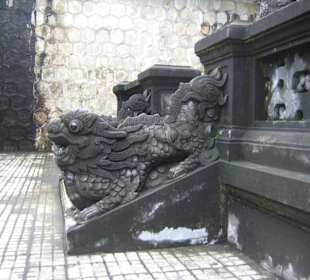 Ein Drachenkopf am Geländer der Stufen.