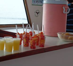 Obst, Brötchen, Säfte und Wasser zum Frühstück