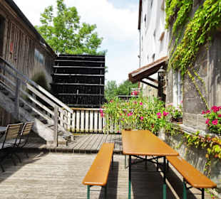 Sitzplätze am Wasserrad des Biergartens