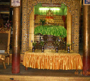 Auf einer Art Altar sitzt der Buddha