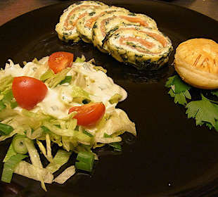 Lachsspinatrolle auf Salatbett mit Blätterteig