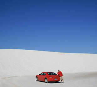 White sands, red car