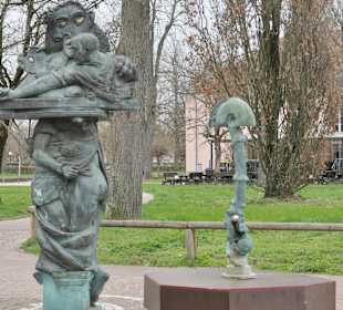 Brunnen und skurrile Figur vor dem Museumstor