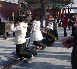 Gläubige entzünden Räucherstäbchen