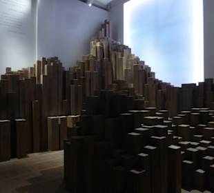 Raum mit Holz-Stelen und Einzelschicksalen