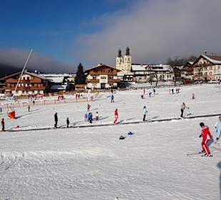 Eltern schauen ihren Kindern beim Schifahren zu