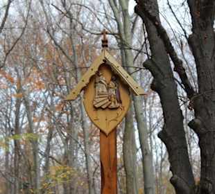 Geschnitzte Motive am Pilgerweg