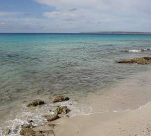 Sandstrand durchsetzt von Felsen und Steinen