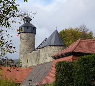 Die Burg mit Bergfried über den Dächern des Dorfes