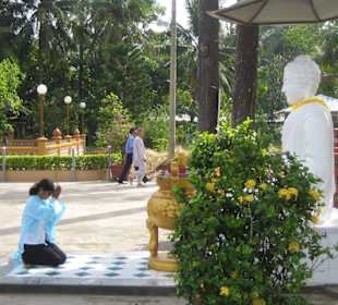 Eine Gläubige im gebet vor dem Buddha.