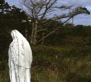 Verwitterte Figur vor der Kirche von Claddagduff