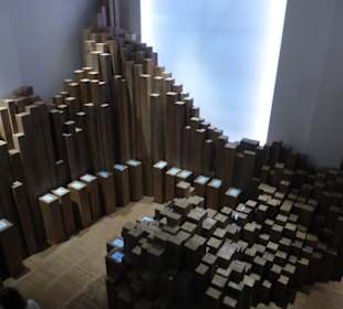 Raum mit Holz-Stelen und Einzelschicksalen