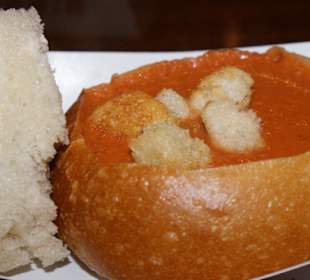 Tomatensuppe im Brot serviert