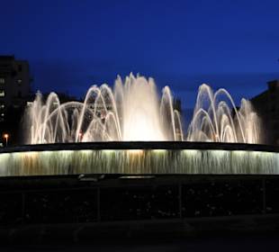 Beleuchteter Brunnen am Abend