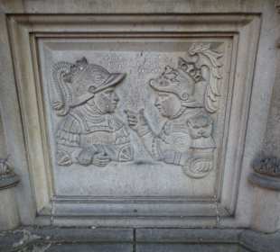 Relieftafeln um den Brunnen