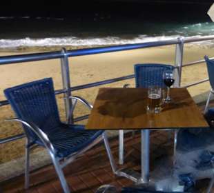 Gute-Nacht-Getränk vor La Cantina am Strand / Meer