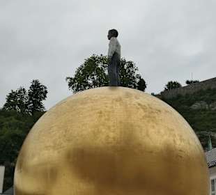 Sphaera – eine große Kugel auf der ein Mann steht